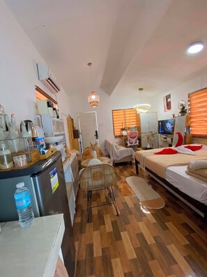 A compact hotel room with a kitchenette, a bed, a seating area, and a television. - Cozy Studio-type bungalow in welcoming Olango island, Lapu-lapu City with AC (Lapu-lapu City)