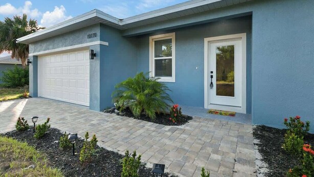 A modern two-story house with a garage, a front door, and a small window. - Luxe Englewood Home Near Beach (Englewood)
