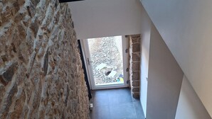 A staircase with stone walls and a view to an outdoor area. - Vacation Rental 2: "La Belle Aire" at Christophe's (Le Fœil)