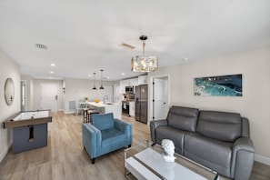 A modern living room with a grey sofa, a blue armchair, and a coffee table.