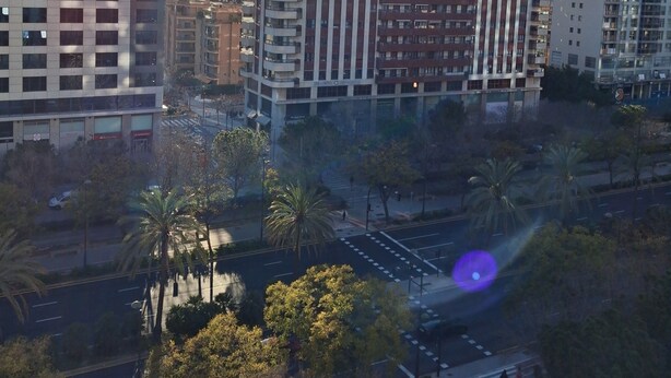 Un grattacielo con numerosi piani, ampie finestre e un cortile centrale con palme.
