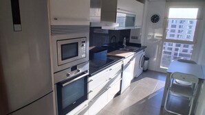 Una cucina moderna con elettrodomestici in acciaio inossidabile, un forno a microonde, un forno e un lavello.
