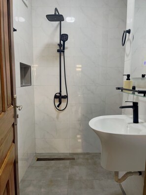 A bathroom with a shower, sink, and toilet. - Cozy 1-bedroom apartment with terrace in Dakar (Dakar)