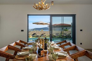 Mesa de comedor para seis personas con vista a una piscina y montañas.