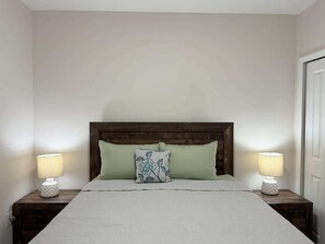 A bedroom with a bed centered between two nightstands, each with a lamp. - Spacious 4BR 2BA Retreat in Port Charlotte (Port Charlotte)