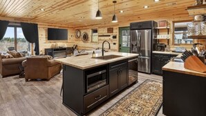 Een chaletinterieur met een keuken, een eethoek en een zithoek.