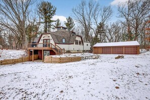 A house with a deck, a garage, and a snow-covered yard.