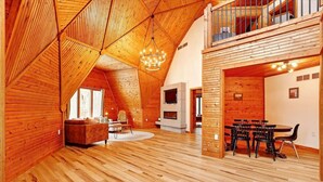 Un loft amplio con pisos de madera, un comedor, una chimenea y un balcón.