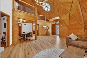 A spacious loft with wooden floors, a dining area, and a loft bed.
