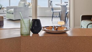 A modern interior with a kitchen counter, dining area, and a view of a lake through large glass doors.