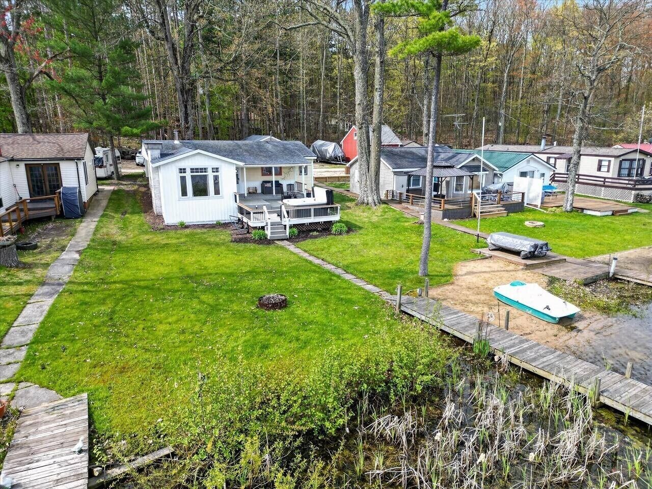 Un terrain de camping doté de plusieurs chalets, d’une zone herbeuse et d’un quai.