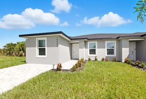 A modern two-story house with a flat roof, a front entrance, and a driveway. - Chic 3BR, 2BA – Brand New! (Englewood)