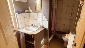 A compact bathroom with a sink, mirror, and toilet.