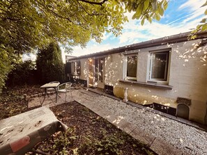 A single-story building with a patio area, a table, and chairs. - The 4th of the Cressonnière (Agny)