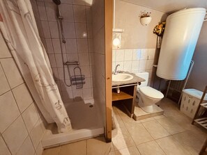 A bathroom with a shower, toilet, sink, and a large water tank. - The 4th of the Cressonnière (Agny)