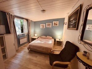 A bedroom with a bed, bedside tables, a chair, a desk, a radiator, and a window with curtains. - The 4th of the Cressonnière (Agny)