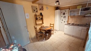 A compact kitchen with a dining area, a refrigerator, and a sink.