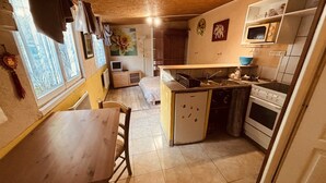A compact kitchen with a dining area, a microwave, and a stove.