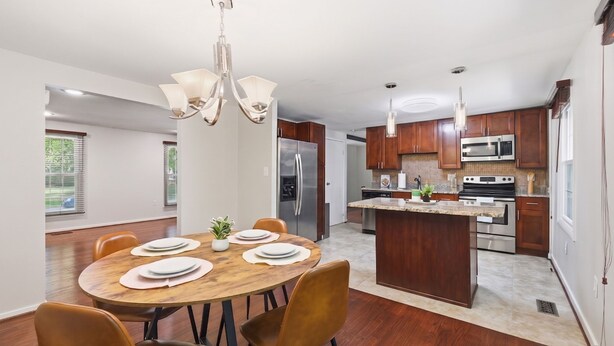 Une cuisine moderne avec des meubles en bois, des appareils en acier inoxydable et un îlot central.