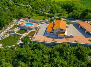 A villa with a swimming pool, stone walls, and a red-tiled roof. - Rustic Haven Villa (Vrgorac)