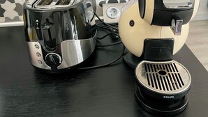 A toaster and a coffee maker on a table with a patterned wall in the background. - Waterfront apartment| Towels and sheets (Saint-Gilles-Croix-de-Vie)