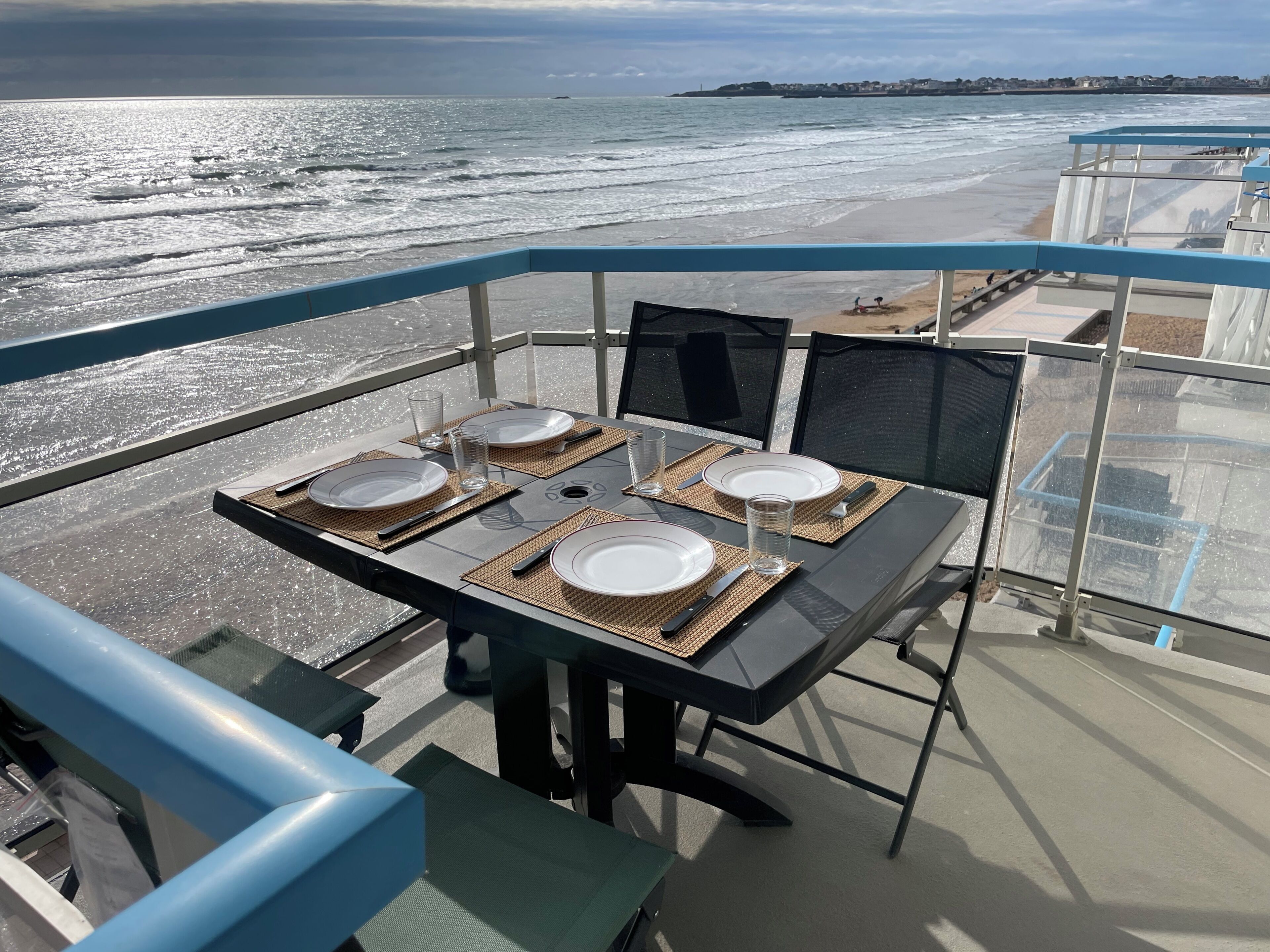 A table set for four with a view of the ocean.