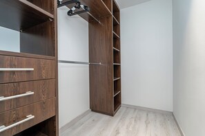 A walk-in closet with wooden shelving and drawers. - Luxy Holló Gozsdu Court Budapest (Budapest)