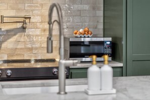 A kitchen with a microwave, eggs in a bowl, a faucet, and a stove. - Stylish Farmstay on 6 Acres • Cowboy Pool • Fresh Eggs • Casita • Fire Pit (Tyler)