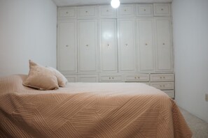 A bedroom with a bed, a wardrobe, and a light fixture. - Arrona" Department (Oaxaca de Juárez)