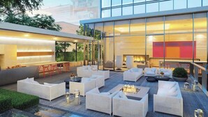 Un moderno espacio lounge al aire libre con asientos y una chimenea.