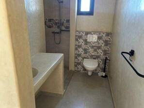A small bathroom with a bathtub, toilet, and shower.