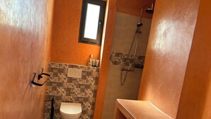 Ein Badezimmer mit Toilette, Dusche und Waschbecken.