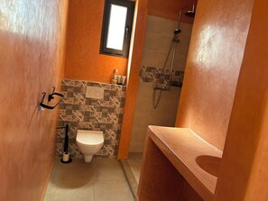 Ein Badezimmer mit Toilette, Dusche und Waschbecken.