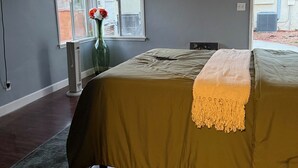 A bedroom with a bed, a ceiling fan, a window, and a radiator. - Quiet, Charming LA Back house — Minutes from SOFI, the Forum & the Beach (Los Angeles)