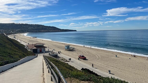 A coastal road leading to a beach with a lifeguard tower, a red vehicle parked on the sand, and a clear blue sky. - Quiet, Charming LA Back house — Minutes from SOFI, the Forum & the Beach (Los Angeles)
