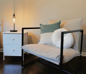 A chair with a metal frame, a white drawer unit, and a wall-mounted light. - Mimosa Light cosy house  Close to DFW & AT&T & six flags (Richland Hills)