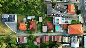 An aerial view of a residential area with houses, a swimming pool, and solar panels. - Ipê Eco Village - Apartments with Kitchen, 5 min. from Beto Carrero World (Penha)