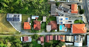 An aerial view of a residential area with houses, a swimming pool, and solar panels. - Ipê Eco Village - Apartments with Kitchen, 5 min. from Beto Carrero World (Penha)