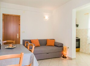 A living room with a sofa, chairs, a table, and a kitchen area. - one bedroom with balconies and sea view A5 (Janjina)