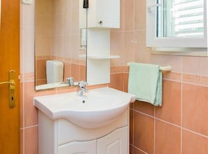 A bathroom with a sink, mirror, and window. - two bedroom with balcony and sea view A6 (Janjina)