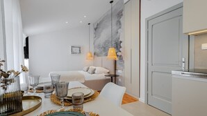 Une chambre d’hôtel moderne comprenant un coin repas, un lit et une kitchenette.