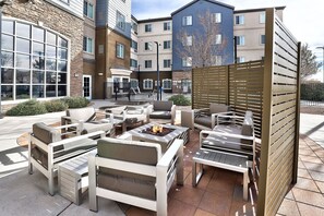 An outdoor seating area with multiple lounge chairs and a fire pit.