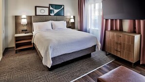A hotel room with a bed, nightstands, a TV, and a wooden cabinet. - Cozy Studio w/ Free Breakfast, Pool & BBQ Area (Albuquerque)
