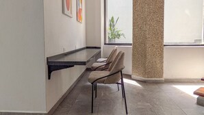 Un interior modern amb zona de seients, finestra amb vistes i obra d'art a la paret.