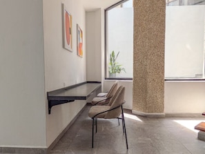 A modern interior with a seating area, a window with a view, and artwork on the wall. - Casa Heredia 1Bed Studio (Guadalajara)