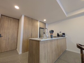 Una cucina moderna con un piano di lavoro in legno, un lavello e una macchina da caffè.
