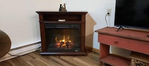 A fireplace with a TV stand in front.