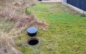 A grassy area with a circular object and a hole in the ground. - 4 Star Holiday Home in Blavand (Blavand)