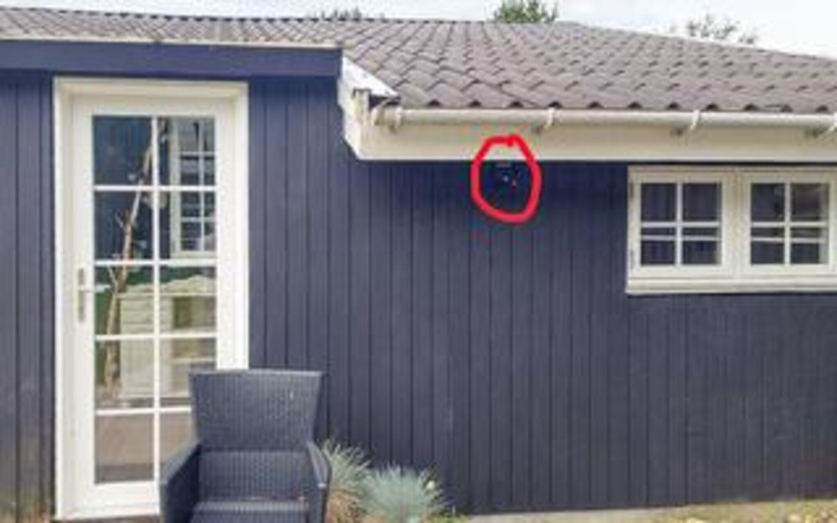 A house with a dark blue exterior, a white door, and a window.