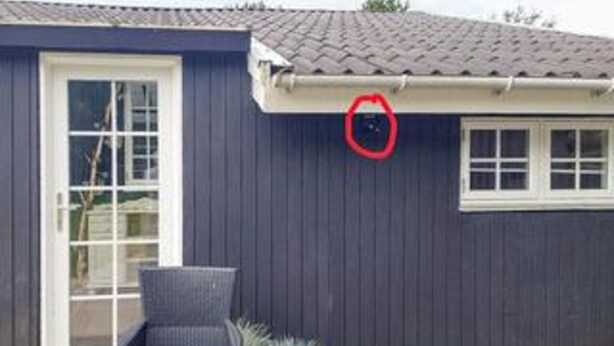 Una casa con facciata blu scuro, una porta bianca e una finestra.